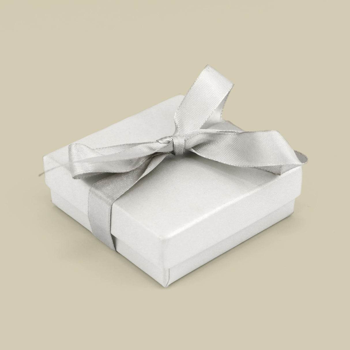 Caixa prateada com laço elegante, ideal para presentes delicados e especiais.